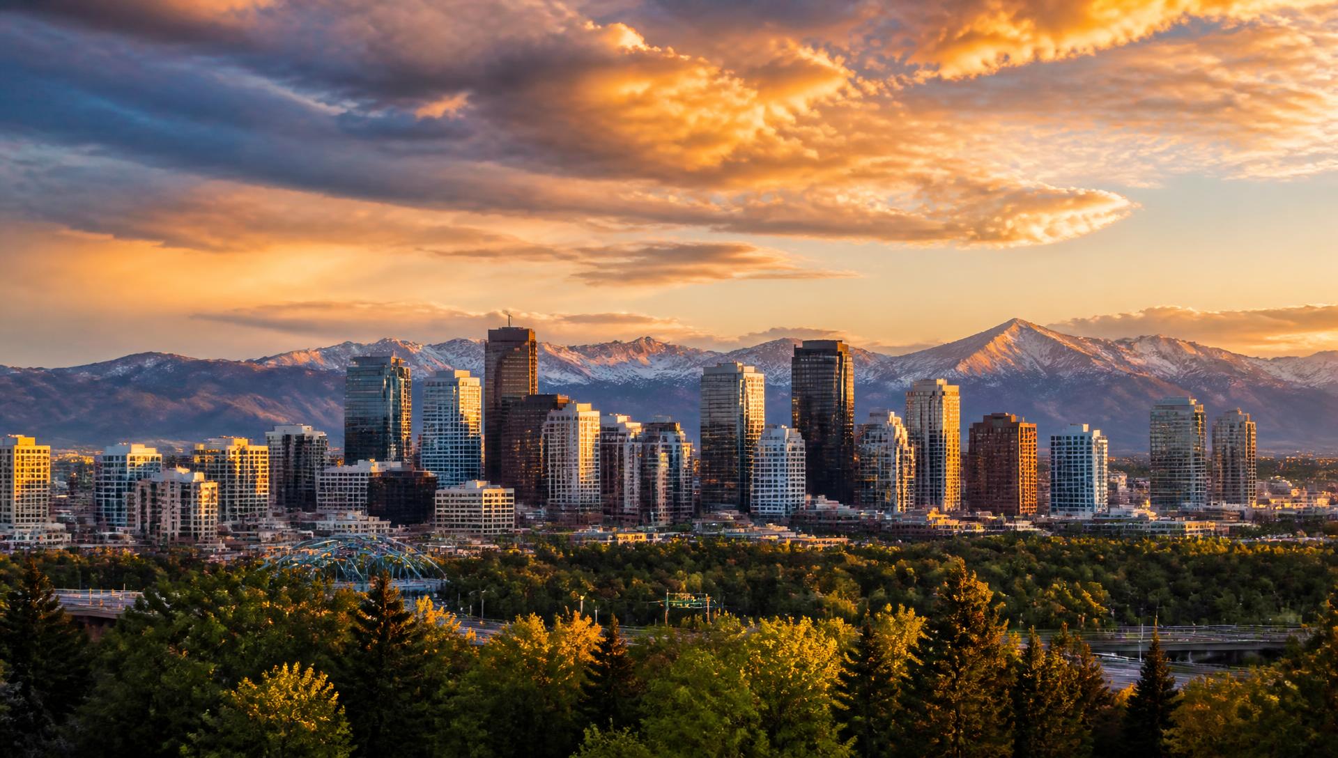 Denver skyline at golden hour with the Rocky Mountains in the distance